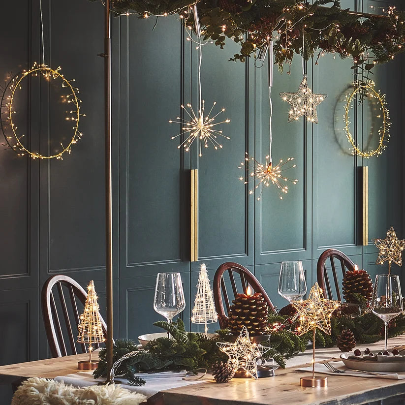 Dining room with festive decorations, including hanging lights and a table set for a meal.