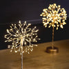 Two decorative LED light sculptures on a wooden surface with a dark background