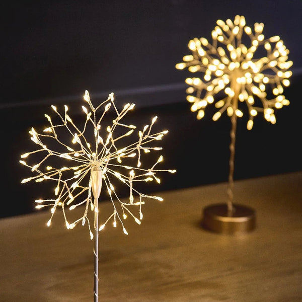 Two decorative LED light sculptures on a wooden surface with a dark background